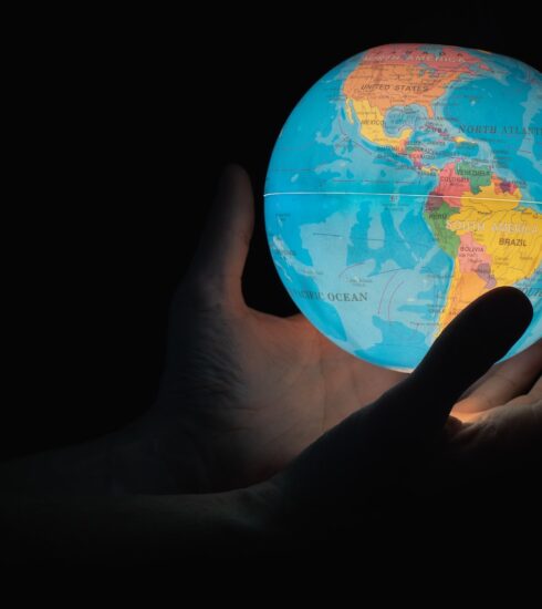 blue and brown globe on persons hand