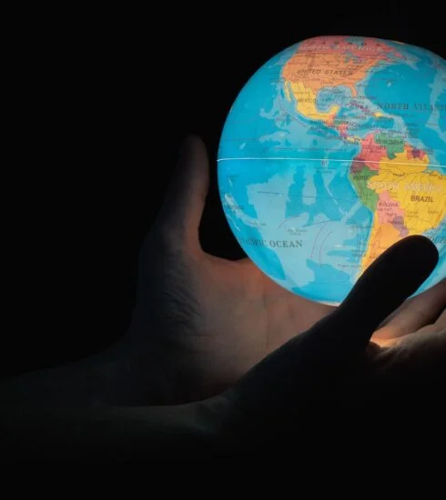 blue and brown globe on persons hand