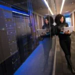 woman in black top using Surface laptop